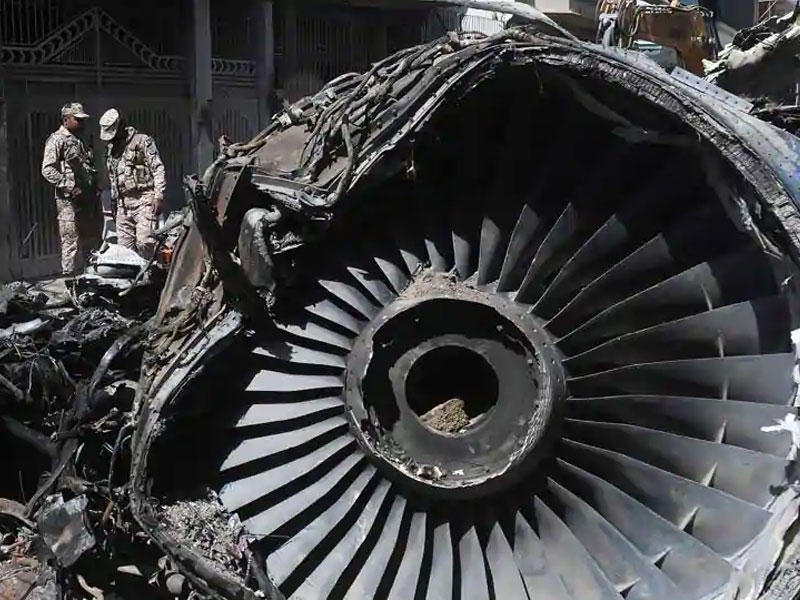 أفراد الأمن يقفون بجانب حطام طائرة في الموقع بعد تحطم طائرة تابعة للخطوط الجوية الباكستانية الدولية