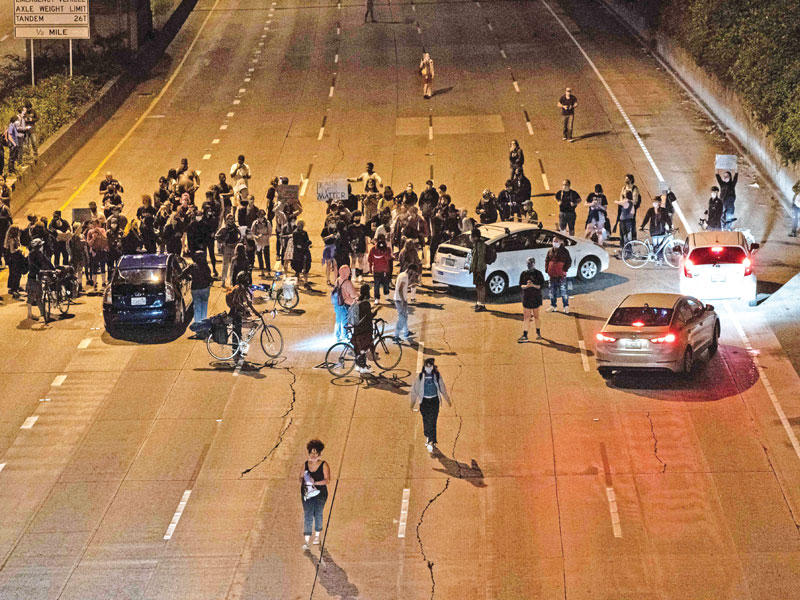 محتجون يغلقون الطريق السريع المؤدي إلى الكابيتول هيل في سياتل أمس الأول (أ ف ب)