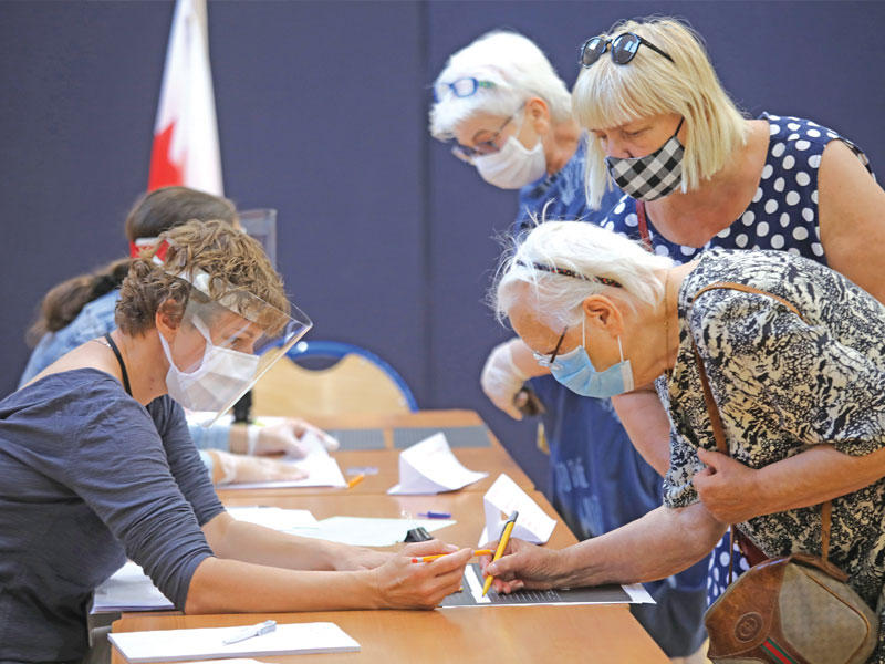 بولنديون بعد ادلائهم بأصواتهم في وارسو أمس (رويترز)