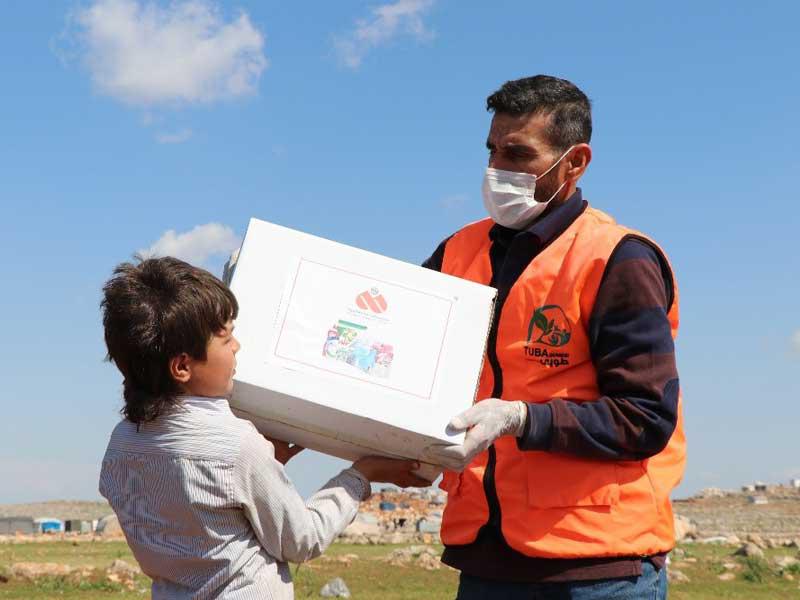 أحد العاملين في جمعية الرحمة العالمية يقوم بتوزيع سلال وقائية في مدينة ادلب السورية