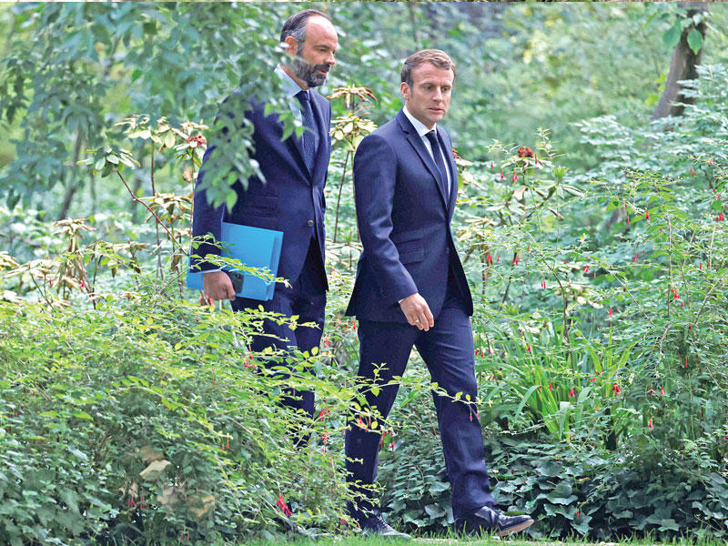 الرئيس إيمانويل ماكرون ورئيس الوزراء الفرنسي الأسبق فرنسوا فيون يصلان لاجتماع مع «مؤتمر المواطنين بشأن المناخ» في الإيليزيه أمس (أ ف ب)