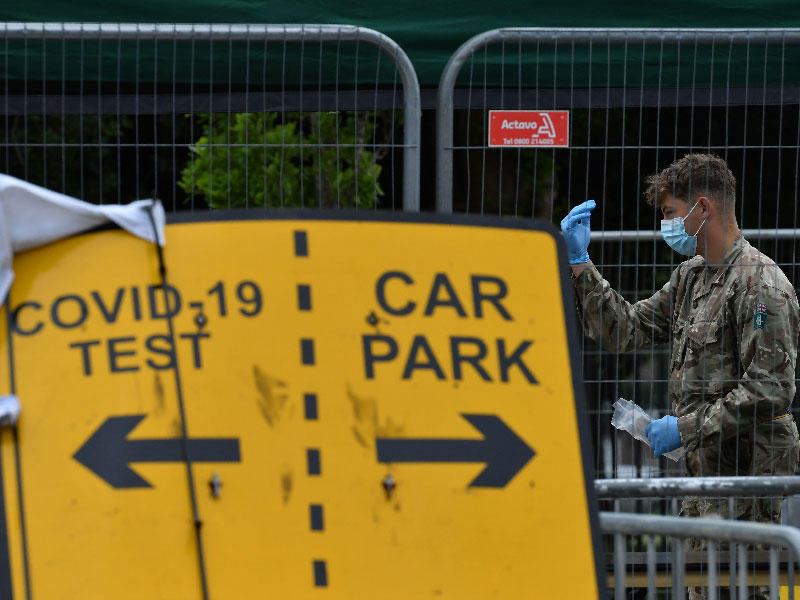 يوجه أحد أفراد القوات المسلحة البريطانية فردًا من الجمهور في مركز اختبار فيروس كورونا
