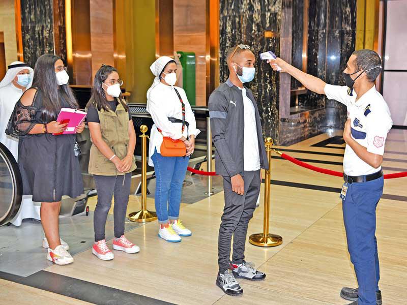 جانب من فحص درجة الحرارة لرواد المجمع قبل الدخول