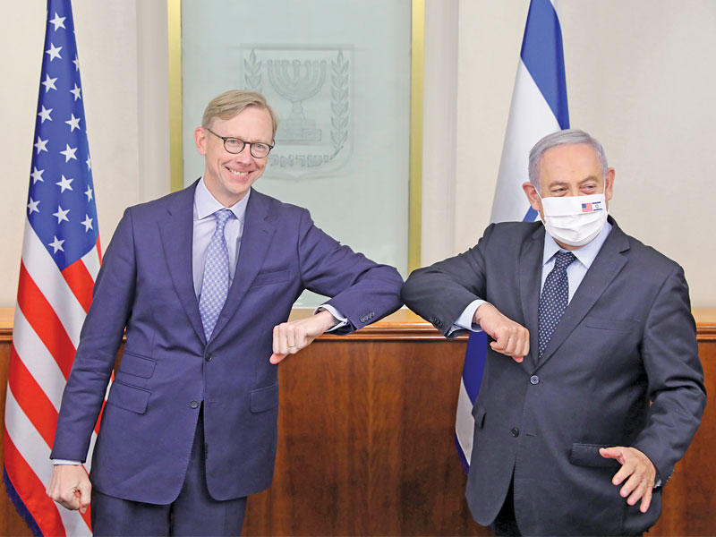 رئيس الوزراء الإسرائيلي بنيامين نتنياهو يحيي المبعوث الأميركي لإيران براين هوك بالمرفق في مكتبه بالقدس أمس (إي بي إيه)