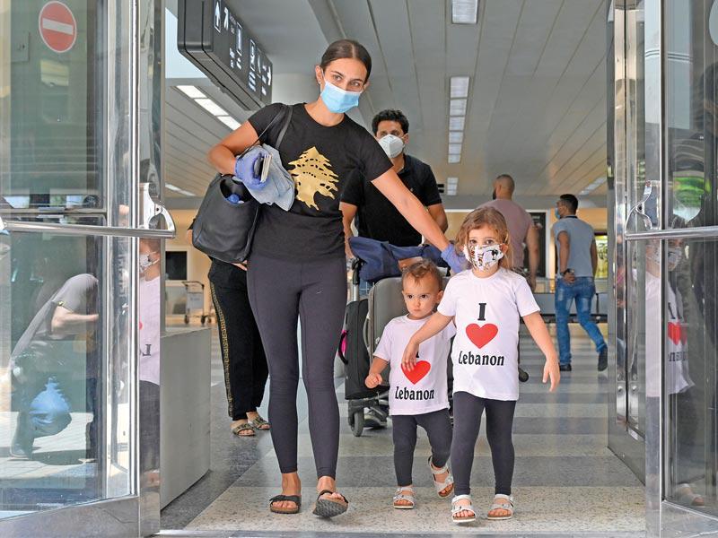 عائلة لبنانية تصل إلى مطار رفيق الحريري الدولي ببيروت أمس في أول يوم من إعادة تشغيله (اي بي ايه)