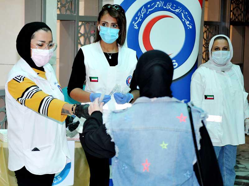 متطوعات «الهلال الأحمر» خلال توزيع المعقمات على رواد مجمع الوزارات