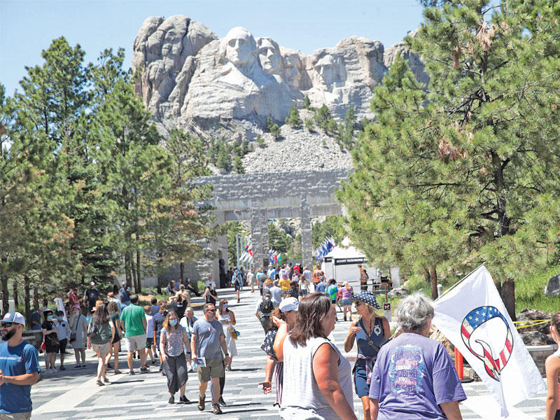 أميركيون في معلم «مونت ريشمور» الوطني بداكوتا الذي سيزوره ترامب بمناسبة ذكرى الاستقلال غداً (أ ف ب)