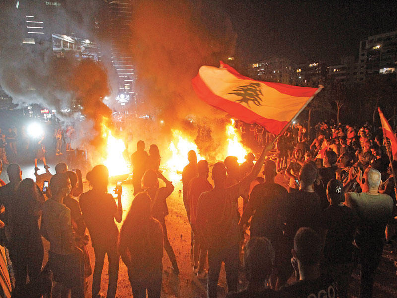 لبنانيون يقطعون الطريق في شمال بيروت بالإطارات المشتعلة احتجاجاً على الوضع المعيشي (اي بي ايه)