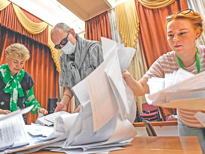 موظفون روس خلال عملية فرز الأصوات في موسكو (أ ف ب)