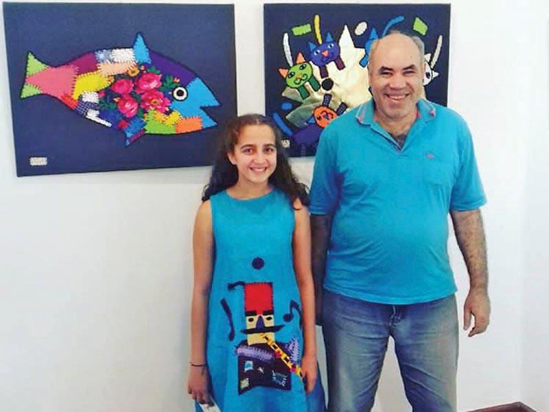 الفنان إبراهيم البريدي مع طفلة في معرضه