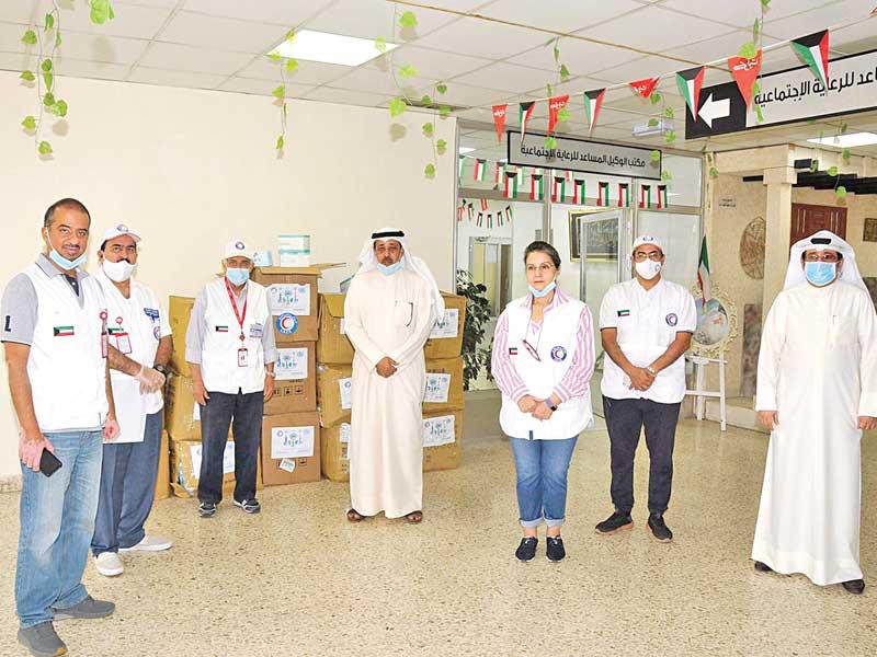  رئیس مجلس ادارة جمعیة الهلال الأحمر د. هلال السایر متوسطاً مسؤولي «الشؤون» و«الهلال الأحمر» خلال تسليم الكمامات إلى مجمع الرعاية