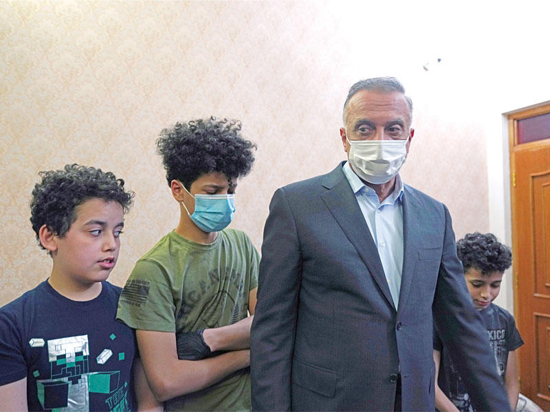 الوزراء العراقي مصطفى الكاظمي مع أولاد هشام الهاشمي في منزله ببغداد أمس الأول (رويترز)