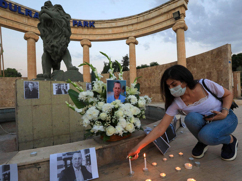 عراقية تضيء شمعة في أربيل أمس الأول في ساحة خصصت لتكريم الأكاديمي هشام الهاشمي الذي اغتيل في بغداد قبل أيام  (أ ف ب)