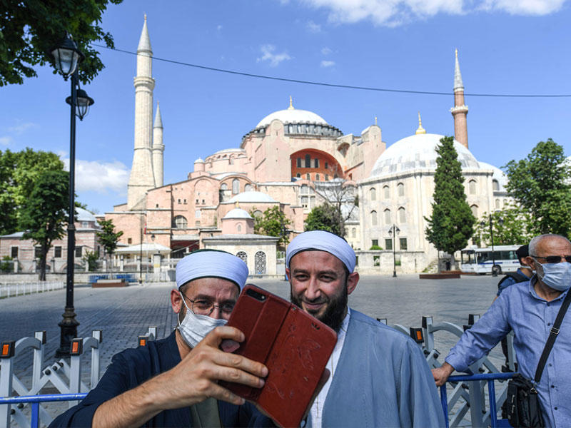 رجلان يلتقطان «سيلفي» أمام «آيا صوفيا» في إسطنبول أمس الأول (ا ف ب)