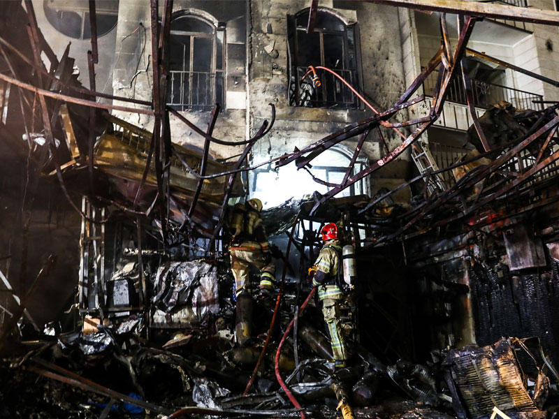 إطفائي إيراني في موقع الانفجار الذي وقع بمستوصف «سينا أطهر» نهاية الشهر الماضي (أ ف ب)