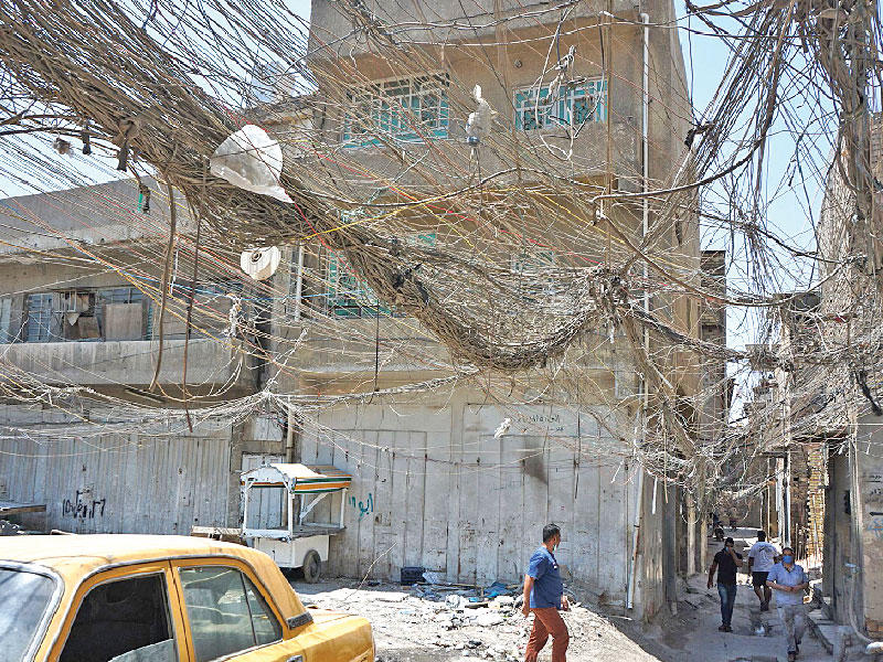 شهدت عدة مناطق بالعراق خلال الساعات الأخيرة تظاهرات بسبب انقطاع الكهرباء وسط الحر الشديد. وفي الصورة كابلات كهربائية تمتد من مولدات خاصة إلى المنازل في بغداد (أ ف ب)n