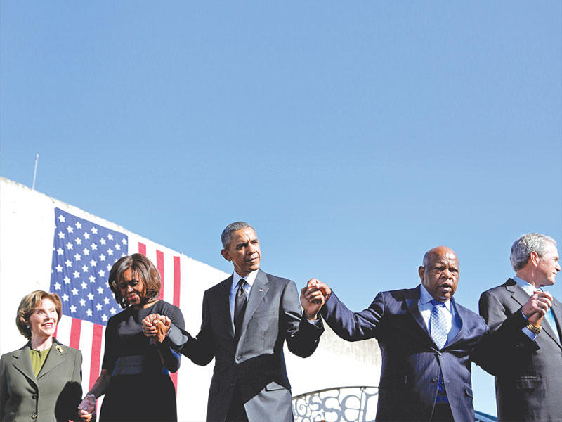 جون لويس متوسطاً الرئيسين أوباما وبوش الابن في 2015 خلال الذكرى الـ 50 لحادثة «الأحد الدموي» على جسر ادموند بيتوس في سلما (رويترز)