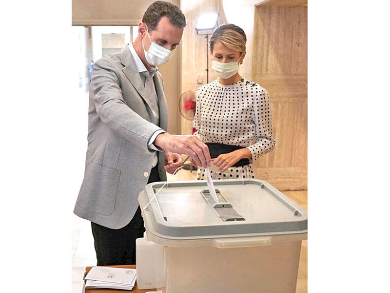 الرئيس بشار الأسد يدلي بصوته مع زوجته في دمشق أمس (رويترز)