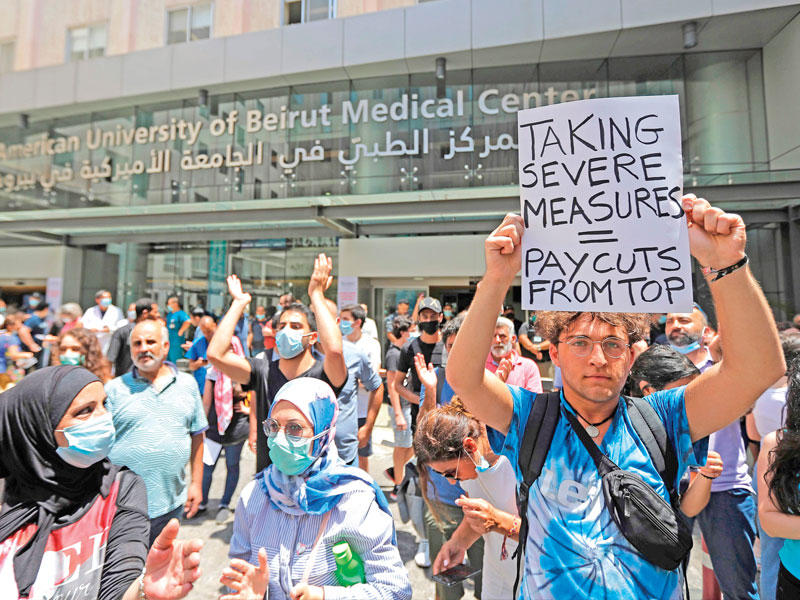 لبنانيون يتظاهرون احتجاجاً على صرف 850 موظفاً من مستشفى الجامعة الأميركية في بيروت أمس (ا ف ب)