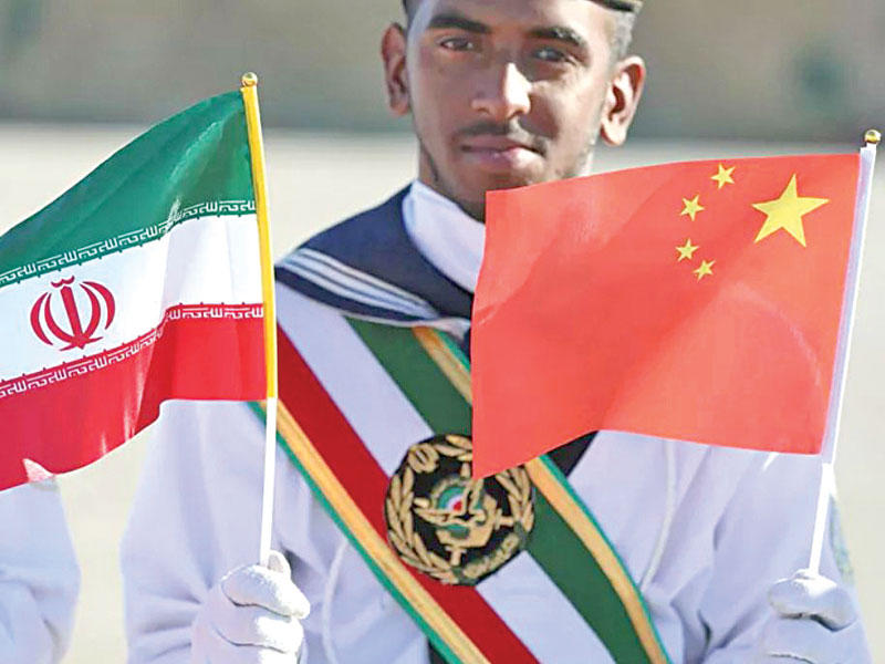 جندي إيراني يحمل علمي الصين وإيران خلال زيارة الرئيس الصيني لطهران في 2016   