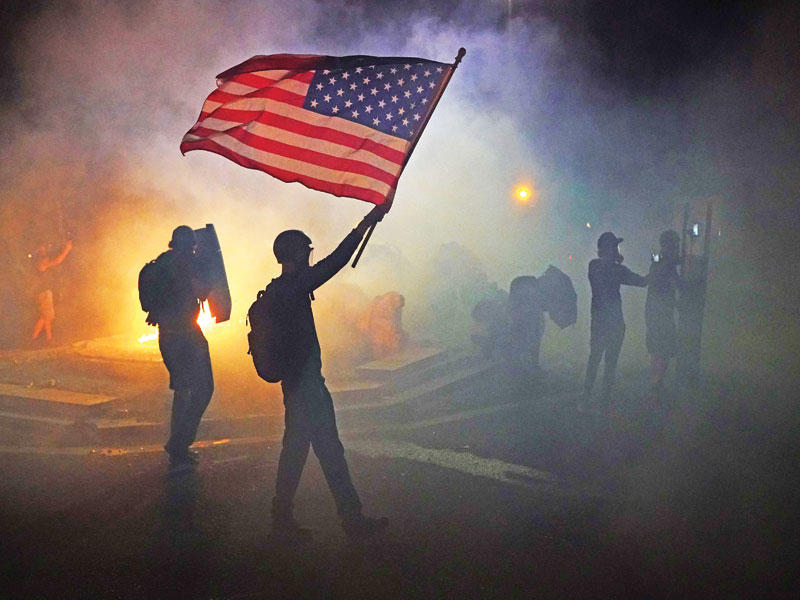 متظاهر يحمل العلم الأميركي في بورتلاند t(أ ف ب)