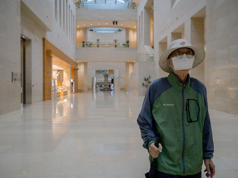 زائر يرتدي قناع وجه يمشي عبر المتحف الوطني الكوري في سيول