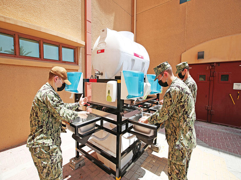 جنود أميركيون يعقّمون أيديهم داخل قاعدتهم في البحرين أمسt (رويترز)