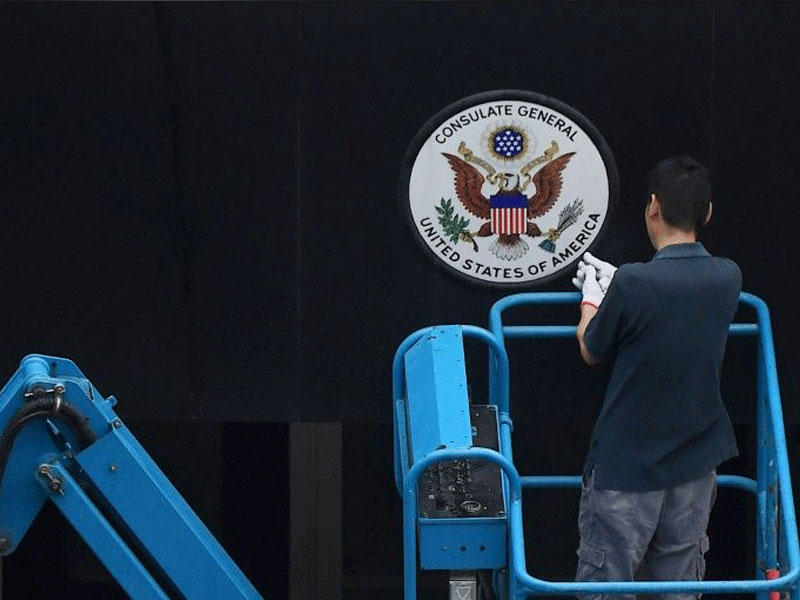 عامل يزيل شعار الولايات المتحدة من أمام القنصلية الأميركية في مدينة تشنغدو الصينية