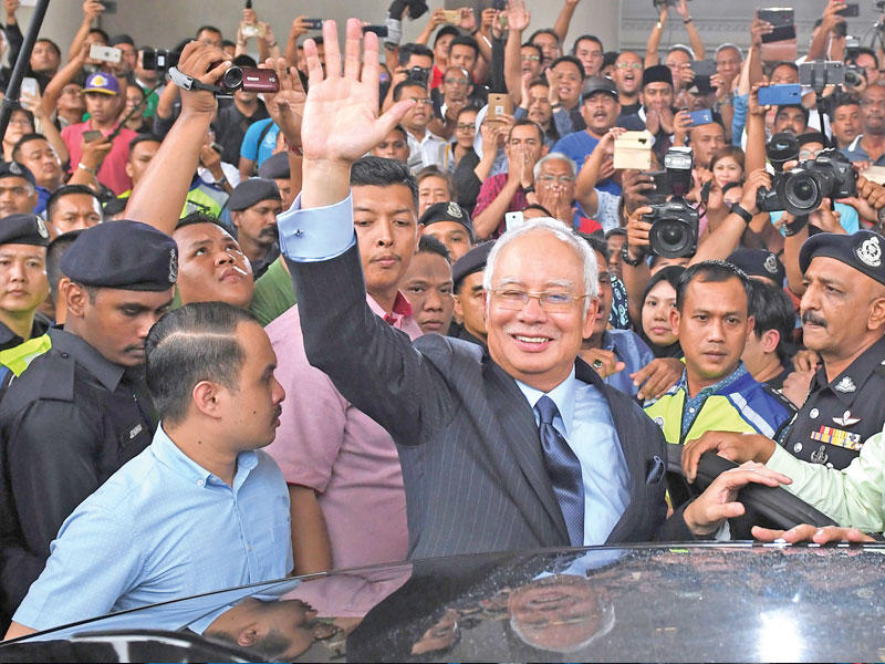 نجيب رزاق يلوح لأنصاره بعد مثوله أمام المحكمة في سبتمبر 2018               (أ ف ب)