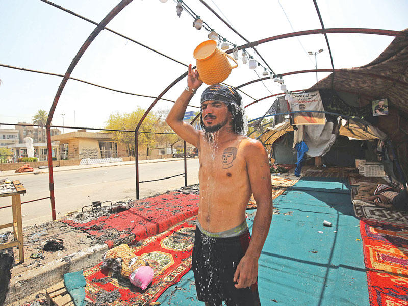 عراقي داخل خيمة اعتصام احترقت خلال الصدامات بين قوات الأمن والمحتجين أمس n(أ ف ب)