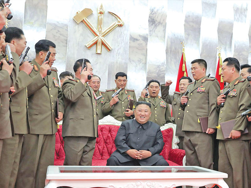  كيم جونغ أون محاط بكبار ضباطه بعد إهدائهم المسدسات (بي بي سي)