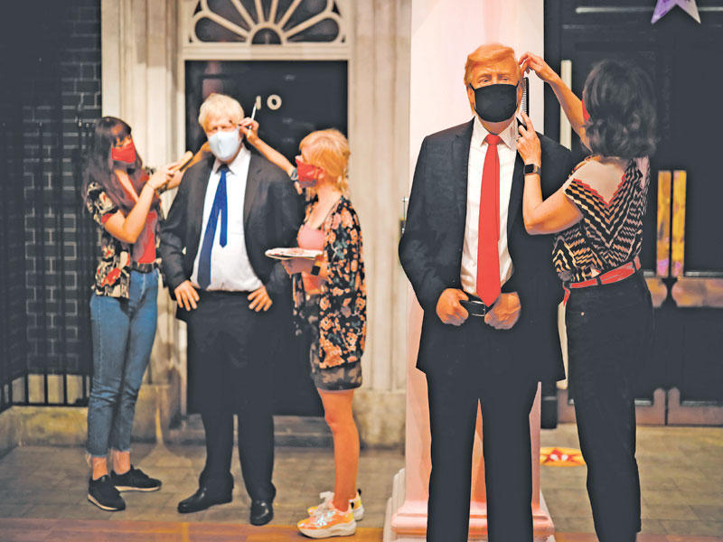 وضع اللمسات الأخيرة على تمثال شمعي لترامب في لندن أمس (أ ف ب)