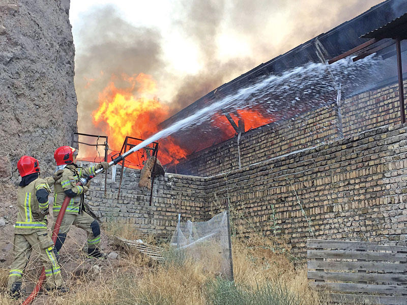 إطفائيون يحاولون إخماد الحريق في المنطقة الصناعية بطهران أمس (رويترز)