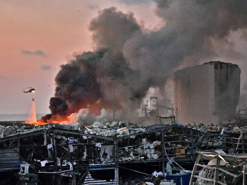 طائرة هليكوبتر تطفئ حريق في مكان انفجار في ميناء بيروت