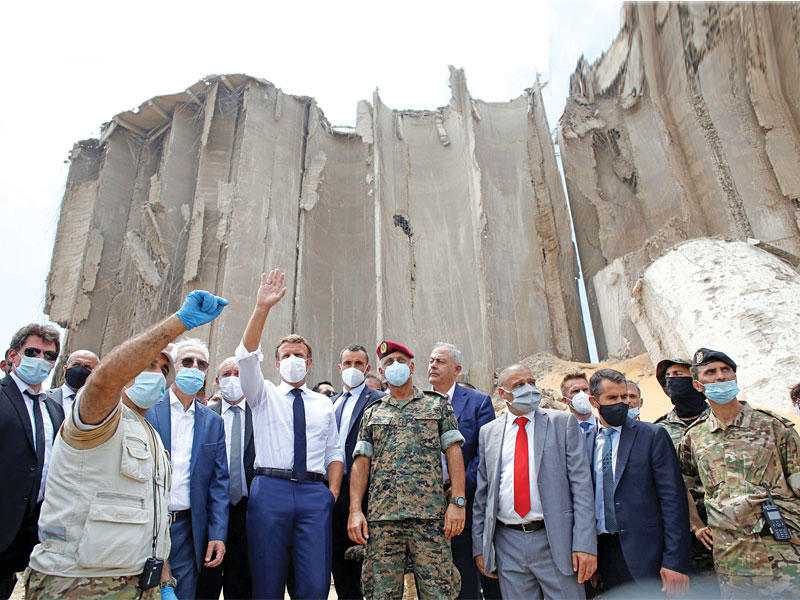 ماكرون متفقداً الدمار في مرفأ بيروت أمس (رويترز)