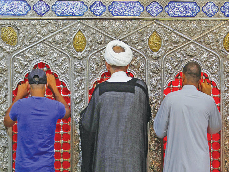 عراقيون شيعة يزورون ضريح الإمام الحسين في كربلاء (رويترز)