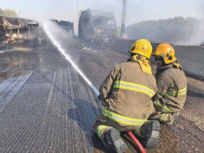 رجلا إطفاء خلال إخماد حريق الصهريج