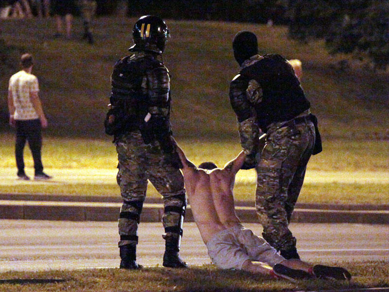 شرطيان يعتقلان أحد المتظاهرين في مينسك أمس الأول (أ ف ب)