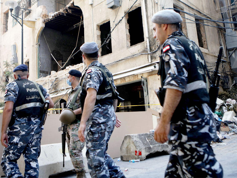 عناصر أمن لبنانيون يتفقدون الدمار في شوارع بيروت (أ ف ب) 