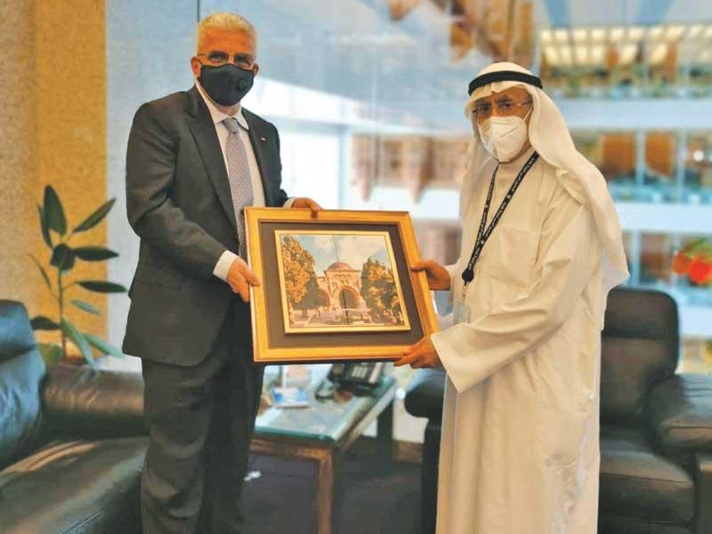  سفير فلسطين لدى الكويت رامي طهبوب مقدّماً هدية تذكارية  للمدير العام للصندوق عبداللطيف الحمد أمس