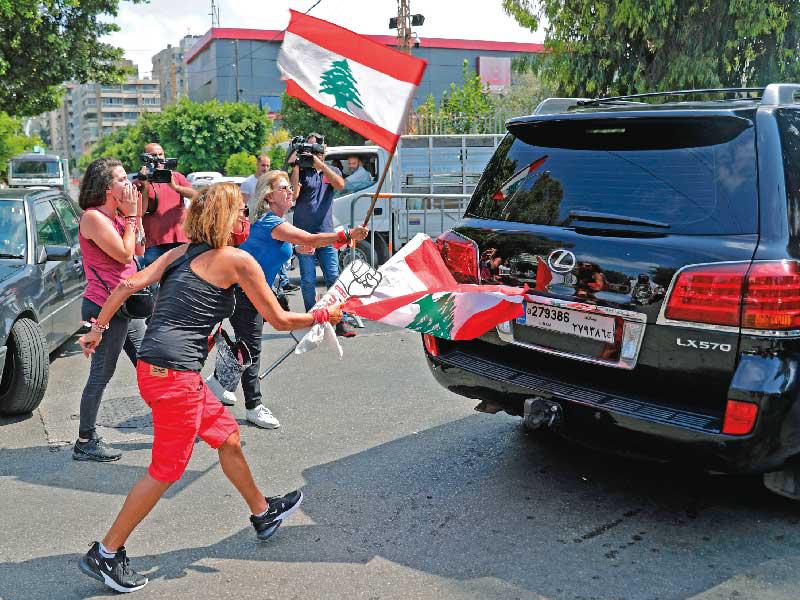 متظاهرات لبنانيات يوقفن سيارة نائب متجه إلى جلسة برلمانية في قصر الأونيسكو أمس (أ ف ب)n