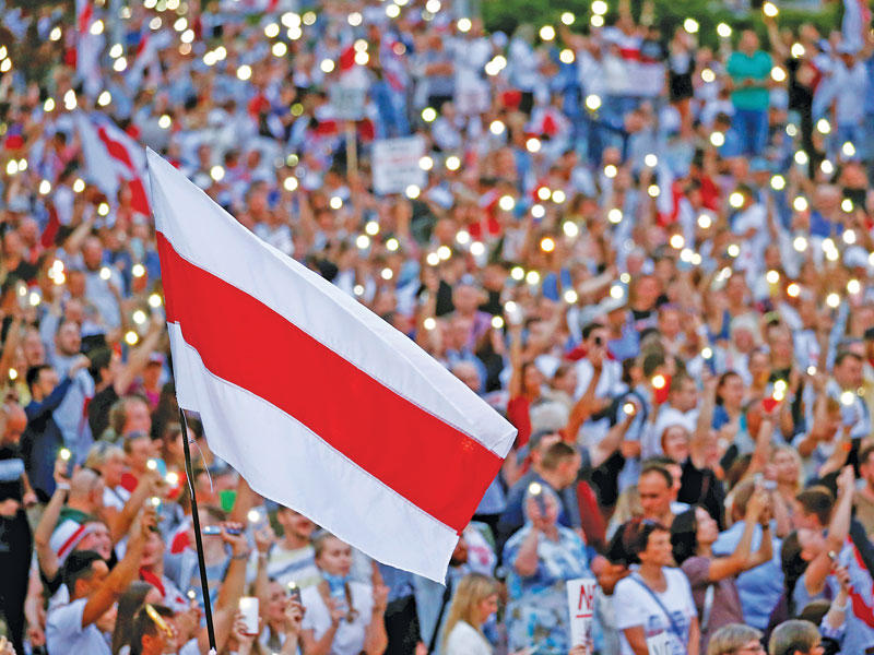 متظاهرون يضيئون هواتفهم خلال تجمّع مناهض للوكاشينكو في ساحة الاستقلال بمينسك مساء أمس الأول (رويترز)