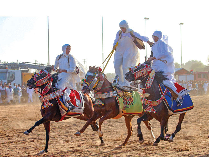 ليبيون يستعرضون بالخيول خلال حفل تقليدي في طرابلس أمس الأول (أ ف ب)