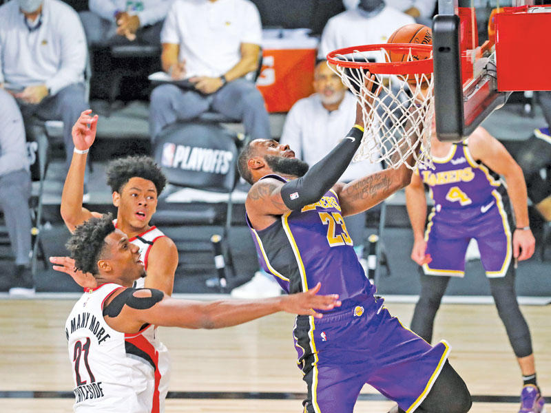 ليبرون جيمس نجم ليكرز يسجل في سلة بورتلاند 