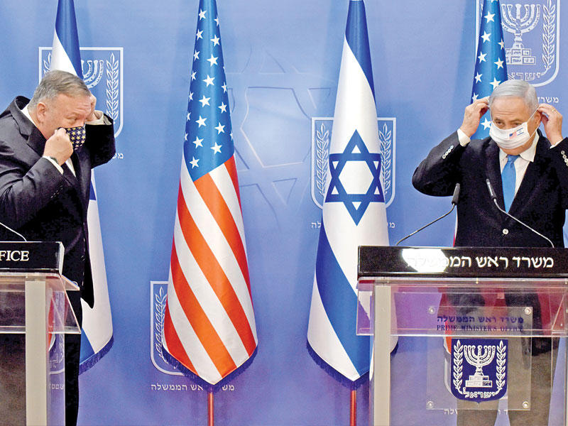 بومبيو ونتنياهو يزيلان الكمامات قبل بدء مؤتمرهما الصحافي المشترك في القدس أمس (ا ف ب)