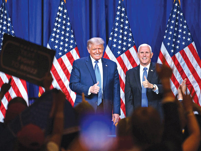 الرئيس الأميركي دونالد ترامب ونائب الرئيس مايك بنس في شارلوت أمس الأول (أ ف ب)