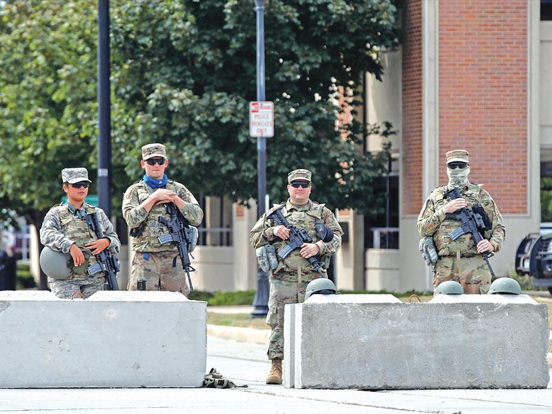 عناصر من الحرس الوطني الأميركي يحرسون مقراً حكومياً في مدينة كينوشا قبيل زيارة ترامب أمس       (رويترز)