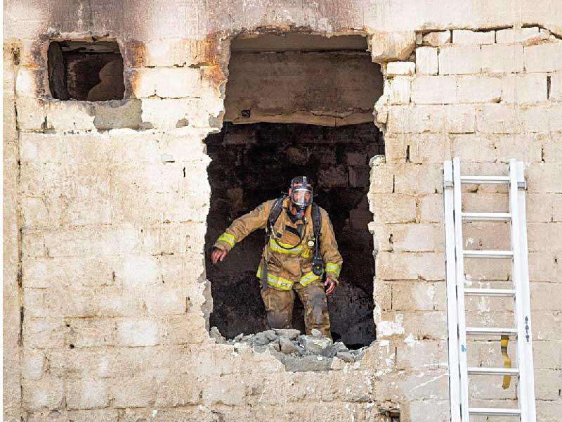 أحد رجال الإطفاء يكافح الحريق