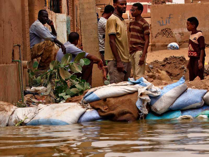 سودانيون يقفون وسط مياه الفيضانات في جزيرة توتي