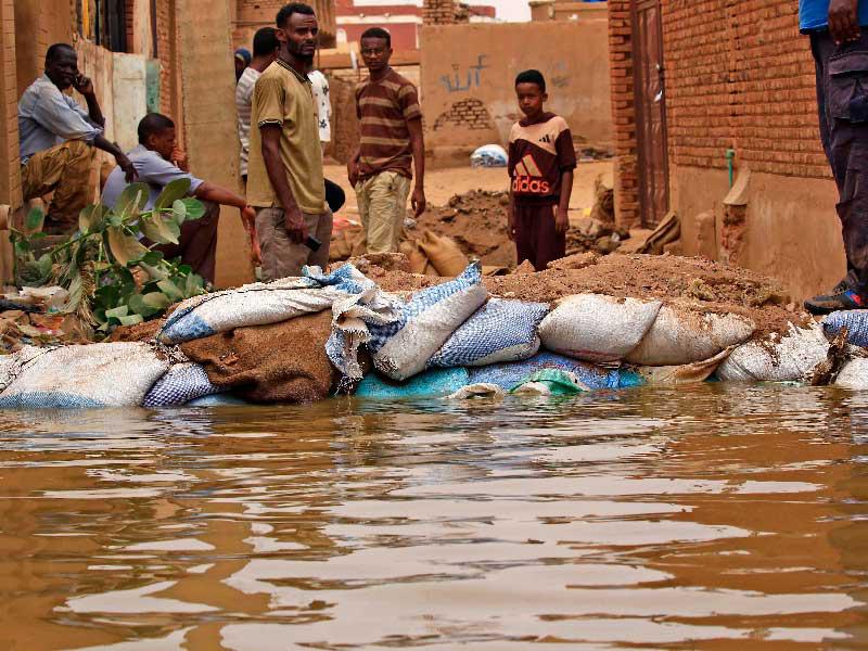 سودانيون يقفون وسط مياه الفيضانات في جزيرة توتي